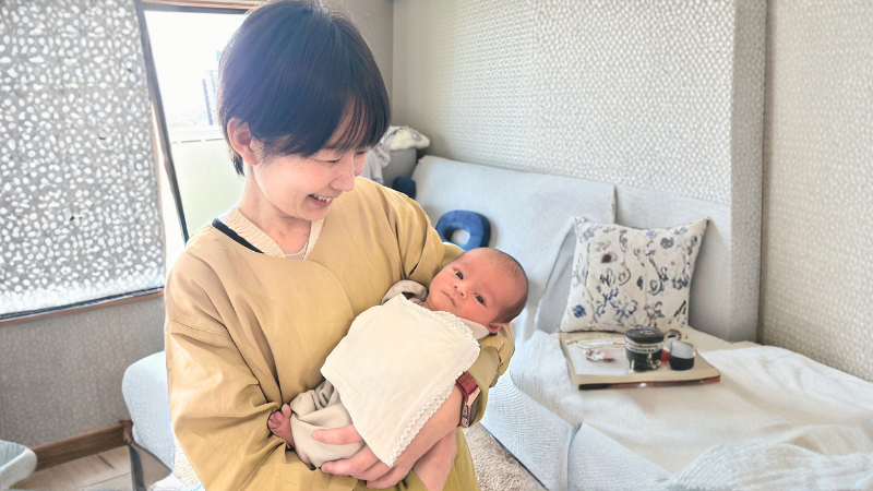 新生児を抱き見つめる院長ふじすえよしみ